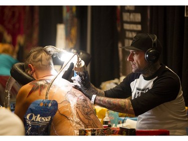 Yan Poliquin works on a back tattoo during the Ottawa Gatineau Tattoo Expo at the Hilton Lac-Leamy on Saturday, Nov. 12, 2016. The expo runs through the weekend.