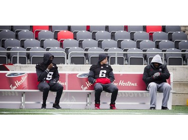 Players try to stay warm on a bench during practice.