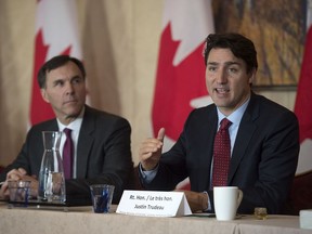 Prime Minister Justin Trudeau takes part in an Investment Summit infrastructure roundtable as Minister of Finance Bill Morneau (left) looks on in Toronto on Monday Nov. 14.