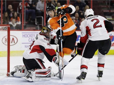 Philadelphia Flyers' Travis Konecny (11) leaps between Ottawa Senators' Craig Anderson (41) and Dion Phaneuf (2) during the second period of an NHL hockey game, Tuesday, Nov. 15, 2016, in Philadelphia.