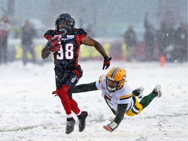 Tristan Jackson (L) of the Ottawa Redblacks runs for the touchdown Jordan Lynch of the Edmonton Eskimos misses his tackle during the second half of the CFL's East Division Final the held at TD Place in Ottawa, November 20, 2016.