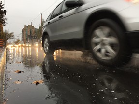 Wet commute on Ottawa streets Thursday. Police reported two collisions involving a cyclist and a pedtrian.