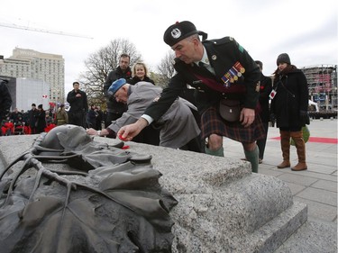 Veterans lay poppies at the Tomb of the Unknown Soldier during Remembrance Day ceremonies in Ottawa on Friday, November 11, 2016.