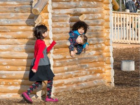 Youngsters enjoy playing in the log house now open to the public as the city quietly opens the controversial Giver 150 Mooney's Bay playground.