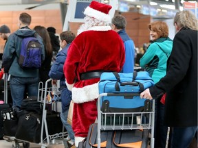 Santa waits patiently with fellow travellers at Ottawa airport Friday. Airport officials say it's the busiest travel day of the year.