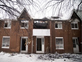As many as 20 people are displaced following a stubborn morning early fire at 69 Raymond St. that heavily damaged several rowhouse units in Centretown Saturday December 31, 2016.   Ashley Fraser/Postmedia