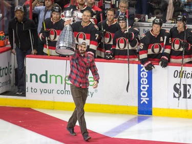 Brad Sinopoli of the Ottawa Redblacks heads out to centre ice to drop the puck from the Grey Cup for the ceremonial face off as the Ottawa Senators take on the Philadelphia Flyers in NHL action at Canadian Tire Centre.