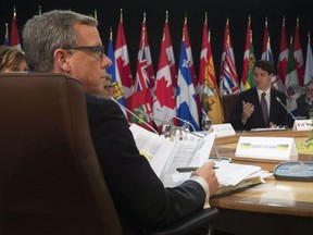Saskatchewan Premier Brad Wall looks on as Prime Minister Justin Trudeau delivers remarks at a First Ministers' meeting in Ottawa in December 2016. Wall has announced he will be stepping down soon.