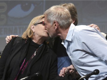 In this July 10, 2015, file photo, Carrie Fisher, left, and Harrison Ford kiss at the Lucasfilm's "Star Wars: The Force Awakens" panel on day 2 of Comic-Con International in San Diego, Calif. Fisher revealed in an interview with People magazine published online on Nov. 15, 2016, that she had an affair with Ford during the filming of the 1977 film, "Star Wars."