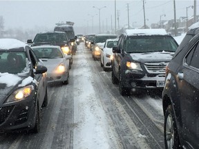Commuters crawl along through the fresh snow on Prince of Wales Drive Monday morning.