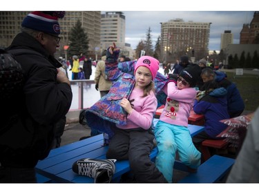 Cousins Amelia Parsons, 8, left, and Alainah Parsons, 8, sit on a picnic table after going for a skate on the Rink of Dreams.
