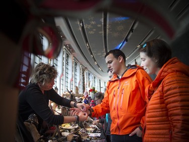 Crowds filtered through the Grand Hall at the Museum of History for the Christmas Market on Saturday, Dec. 3, 2016. The event started Thursday and runs through Sunday. Jimmy Bernard along with Marie-Claude Pellerin finds a bracelet at Manon Tremblay's Stone Era display.