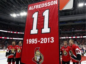 Former Ottawa Senators player Daniel Alfredsson, second right, along with former teammates Chris Neil (25), Chris Phillips, second left and Erik Karlsson (65) pose as a banner with Alfredsson's jersey number 11, is retired and raised to the rafters in Ottawa, Thursday December 29, 2016.