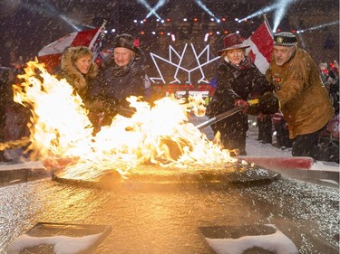 Sharon Johnston, left, Gov. Gen. David Johnston, Minister of Canadian Heritage Mélanie Joly and Elder Albert Dumont re-light the Centennial Flame on Parliament Hill on New Year's Eve, Saturday, Dec. 31, 2016 in Ottawa.
