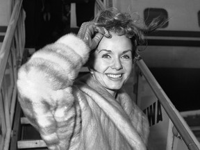 In this March 6, 1959, file photo actress Debbie Reynolds boards an airliner in New York en route to Spain where she will film a new picture. Reynolds, star of the 1952 classic "Singin' in the Rain" and mother of Carrie Fisher, died Wednesday, Dec. 28, 2016, according to her son Todd Fisher. She was 84.