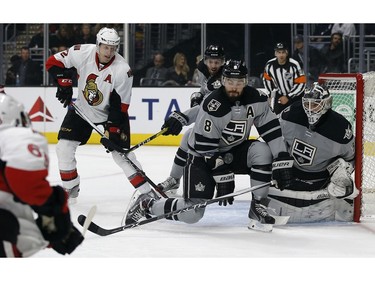 Los Angeles Kings defenceman Drew Doughty blocks a shot with goalie Peter Budaj from Ottawa's Mike Hoffman, left, with defenceman Dion Phaneuf looking on.