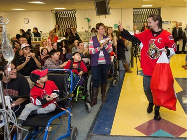 Erik Karlsson arrives carrying a bag of gifts as the Ottawa Senators make their annual Christmas visit to CHEO and visit with some of the children and staff. They also brought gifts including a DSLR camera, video games, movies, blankets and plush Sparty dolls for CHEO's use in its effort to enhance the lives of hospital patients.