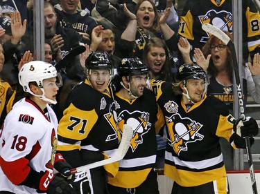 The Pittsburgh Penguins' Justin Schultz, centre, celebrates his goal with teammates Evgeni Malkin (71) and Carl Hagelin in the second period.