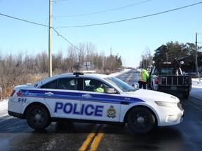 Police block off Mitch Owens Drive in Greely Friday following a collision between a dump truck and a car. Two people in the passenger vehicle were killed.