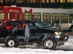 A police officer walks away from the scene of an early morning collision between a OC Transpo bus and a Toyota 4-Runner SUV in January, 2008. The crash proved fatal for three occupants of the SUV.