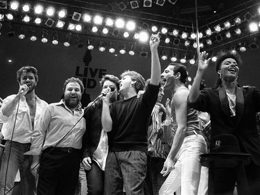 In this July 13, 1985, file photo, from left, George Michael of Wham!, concert promoter Harvey Goldsmith, Bono of U2, Paul McCartney, concert organizer Bob Geldof and Freddie Mercury of Queen join in the finale of the Live Aid famine relief concert, at Wembley Stadium, London. Michael, who rocketed to stardom with WHAM! and went on to enjoy a long and celebrated solo career lined with controversies, has died, his publicist said Sunday, Dec. 25, 2016. He was 53.