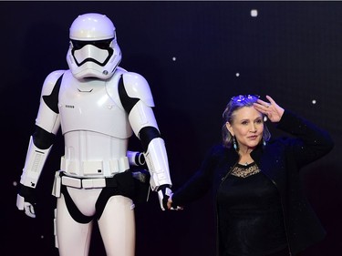 (FILES) This file photo taken on December 16, 2015 shows US actress Carrie Fisher (R) posing with a storm trooper as she attends the opening of the European Premiere of "Star Wars: The Force Awakens" in central London.