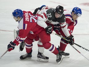 Team Canada forward Anthony Cirelli, centre, is taken out of the play by Team Czech Republic's Jakub Zboril, left, and Frantisek Hrdinka, right, during second period World Junior pre-tournament hockey action Wednesday December 21, 2016 in Ottawa.