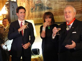 From left, Prime Minister Justin Trudeau joins Mila Mulroney and her husband, former prime minister Brian Mulroney, and Ambassador Nicolas Chapuis (not seen) in a toast at the Embassy of France on Tuesday, December 6, 2016, following the presentation of the insignia of Commander of the National Order of the Legion of Honour to Mulroney.