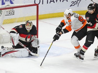 Goalie Mike Condon barely stops the shot from Jakub Voracek with Cody Ceci (R) looking on in the second period as the Ottawa Senators take on the Philadelphia Flyers in NHL action at Canadian Tire Centre.