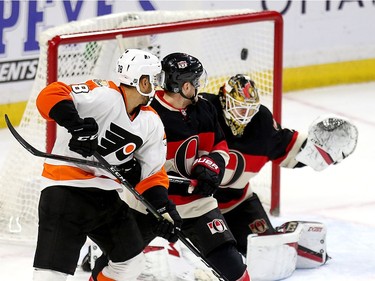 Goalie Mike Condon (R) has Philadelphia's second goal sail past him with Pierre-Edouard Bellemare (L) and Chris Wideman (C) looking on  in the second period as the Ottawa Senators take on the Philadelphia Flyers in NHL action at Canadian Tire Centre.