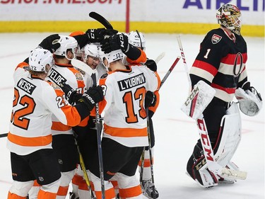 Goalie Mike Condon skates past the celebrating Flyers players after they won the game in overtime as the Ottawa Senators take on the Philadelphia Flyers in NHL action at Canadian Tire Centre.