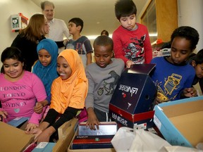 Hassan Noureddine and his wife, Magda Khatib (rear), delivered 60 pairs of new boots to children at Charles H. Hulse Public School Friday (Dec. 16, 2016) in honour of their slain son, Zack, 25, who was killed almost a year ago during a robbery in Toronto.