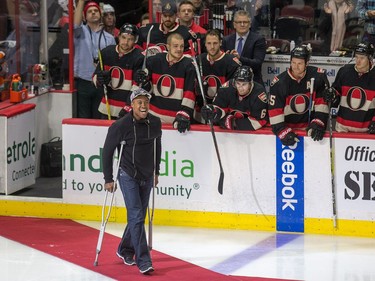Henry Burris of the Ottawa Redblacks heads out to centre ice to drop the puck from the Grey Cup for the ceremonial face off as the Ottawa Senators take on the Philadelphia Flyers in NHL action at Canadian Tire Centre.