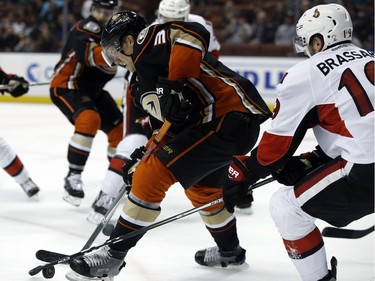 Anaheim Ducks left wing Jakob Silfverberg, left, of Sweden, vies for the puck against Ottawa Senators center Derick Brassard, right, during the second period of an NHL hockey game in Anaheim, Calif., Sunday, Dec. 11, 2016.