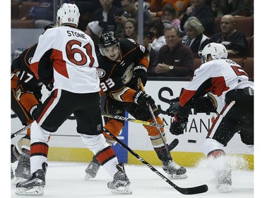 Anaheim Ducks left wing Jakob Silfverberg (33), of Sweden, shoots the puck between Ottawa Senators right wing Mark Stone (61) and defenseman Cody Ceci (5) during the second period of an NHL hockey game in Anaheim, Calif., Sunday, Dec. 11, 2016.