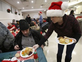 Jodie Keough serves a turkey dinner to Brian Boyd at the Salvation Army Ottawa Booth Centre's annual Christmas dinner in Ottawa on Saturday, Dec. 10, 2016.