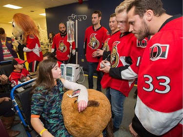 Juliette Dorion, 11, chats with Frederik Claesson, (from right) and Ryan Dzingel, as the Ottawa Senators make their annual Christmas visit to CHEO and visit with some of the children and staff. They also brought gifts including a DSLR camera, video games, movies, blankets and plush Sparty dolls for CHEO's use in its effort to enhance the lives of hospital patients.