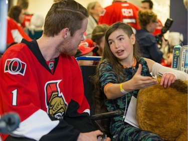 Juliette Dorion, 11, makes a point to goalie Mike Condon as the Ottawa Senators make their annual Christmas visit to CHEO and visit with some of the children and staff. They also brought gifts including a DSLR camera, video games, movies, blankets and plush Sparty dolls for CHEO's use in its effort to enhance the lives of hospital patients.