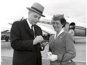 Circa 1957: A photo of John Diefenbaker signing an autograph for a stewardess. (University of Saskatchewan Archives)