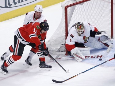 Ottawa Senators' Mike Condon (1) makes a save on a shot by Chicago Blackhawks' Andrew Desjardins (11) as Marc Methot also defends during the first period of an NHL hockey game, Tuesday, Dec. 20, 2016, in Chicago.
