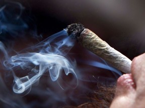 A young man smokes a marijuana joint.