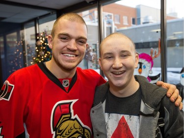 Mark Borowiecki gives cancer patient Tanner Stevenson, 15, a laugh as they joke about looking alike as the Ottawa Senators make their annual Christmas visit to CHEO and visit with some of the children and staff. They also brought gifts including a DSLR camera, video games, movies, blankets and plush Sparty dolls for CHEO's use in its effort to enhance the lives of hospital patients.