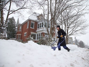 Mary Erramu clears her driveway along Byron Ave as the region is blanketed with fresh snow overnight.