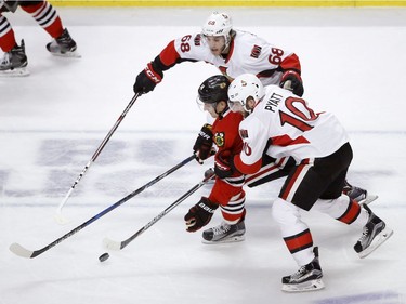 Ottawa Senators' Mike Hoffman (68) and Tom Pyatt (10) pressure Chicago Blackhawks' Richard Panik for the puck during the first period of an NHL hockey game Tuesday, Dec. 20, 2016, in Chicago.