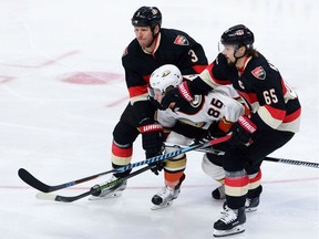 Anaheim Ducks' Ondrej Kase, centre, gets pushed around by Ottawa Senators' Marc Methot, left, and Erik Karlsson during second period NHL hockey action in Ottawa on Thursday, Dec. 22, 2016.