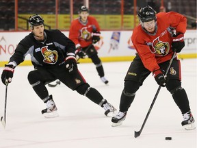 Marc Methot (L) keeps close watch on Daniel Alfredsson (R) as the Ottawa Senators practice. File photo 2013.