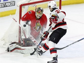 Ottawa Senators goaltender Mike Condon makes a save as the New Jersey Devils' Kyle Palmieri looks on during the second period at the Canadian Tire Centre on Saturday, Dec. 17, 2016.