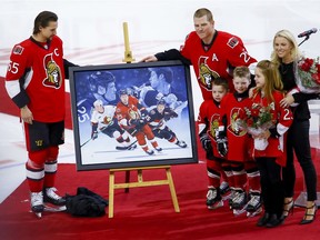 Ottawa Senators right wing Chris Neil (25) poses for photos with Sens captain Erik Karlsson along with his wife Caitlin and their three children Hailey, Cole, and Finn during a ceremony to celebrate his 1000th NHL game prior to the game against the San Jose Sharks at the Canadian Tire Centre on Wednesday December 14, 2016. Errol McGihon/Postmedia