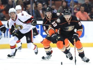 Jakob Silfverberg #33 and Josh Manson #42 of the Anaheim Ducks skate past Kyle Turris #7 of the Ottawa Senators during the first period of a game at Honda Center on December 11, 2016 in Anaheim, California.