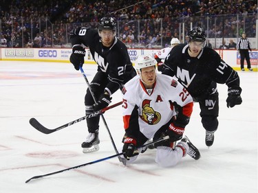 Brock Nelson #29 and Thomas Hickey #14 of the New York Islanders conmbine to stop Chris Neil #25 of the Ottawa Senators during the first period at the Barclays Center on December 18, 2016 in the Brooklyn borough of New York City.